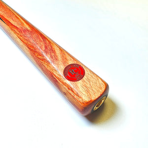 Close-up of Premium Cues ICON No.002 butt end showing the red Icon Authenticator badge embedded in the rich wood grain handle.