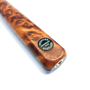 Close-up of Prestige Cues Green Plate 4 snooker cue butt with 'Handmade in Scotland' badge on polished Thuya burr wood finish.