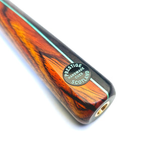 Close-up of Prestige Cues Green Plate snooker cue butt showing handmade Scotland badge and detailed wood splicing with mint veneer.